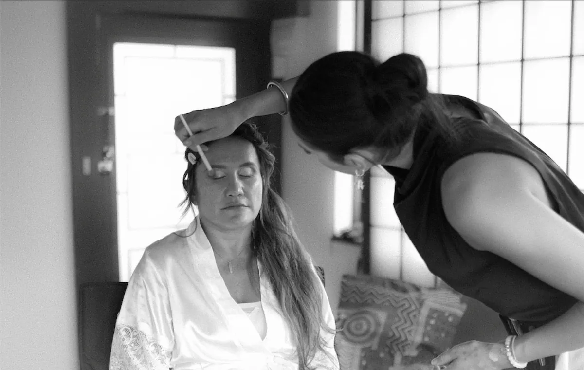 Georgia applying eyeshadow to a bride, in black and white